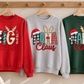 Red GiGi Claus, grey MAMA Claus and green NANA Claus adult Christmas sweatshirts hanging from a wooden rack.