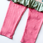 Close-up of green ruffle trim and pink leggings on girls Christmas outfit
