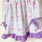 Detail of bow print fabric, ruffle hem, and side ribbon ties
