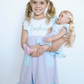 Girl holding doll in matching dress