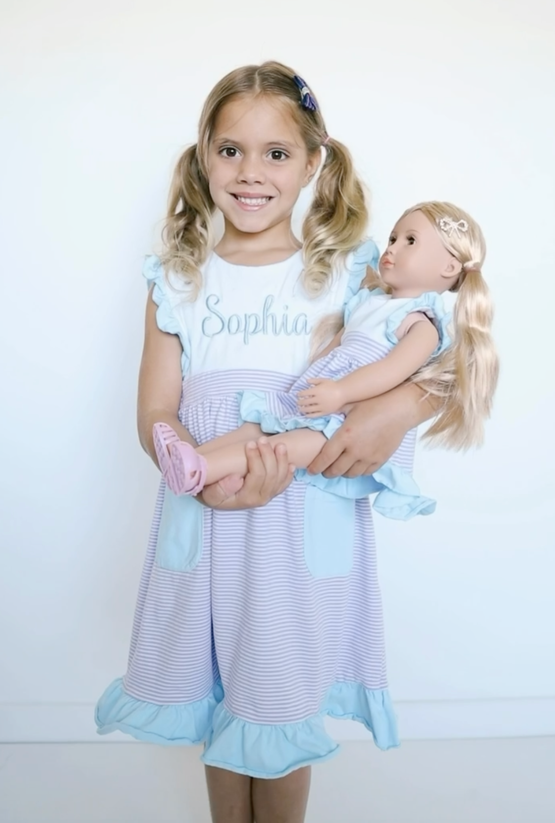 Girl holding doll in matching dress