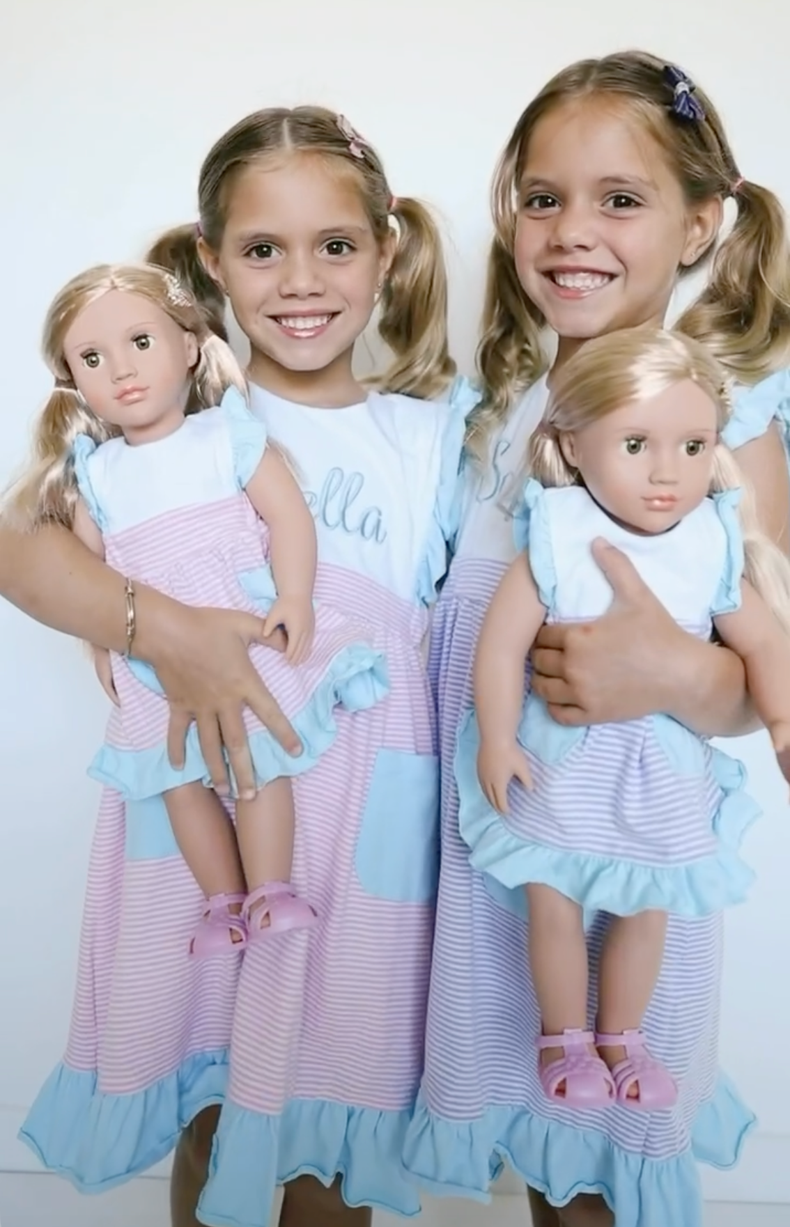 Close-up of girls with dolls in matching dresses